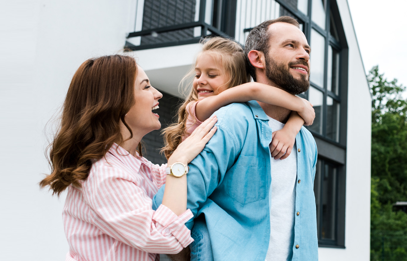 Photo of a family of 3 with daughter on father's back